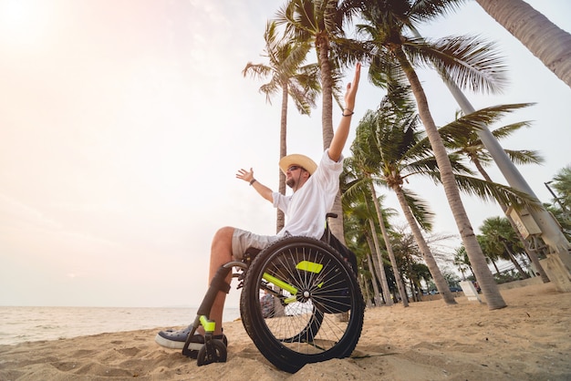 Foto hombre discapacitado en silla de ruedas en la playa.