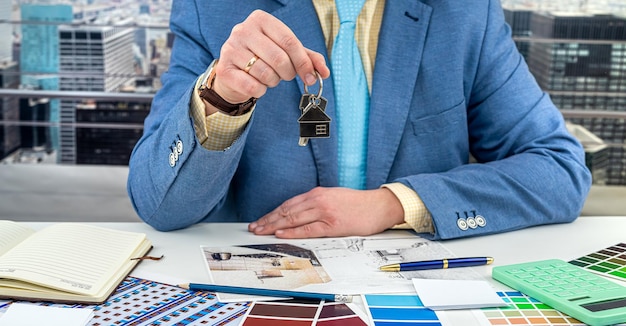 Un hombre con un diseñador de trajes clásico recibió las llaves de la casa en la que trabajará Concepto de diseño de nueva casa