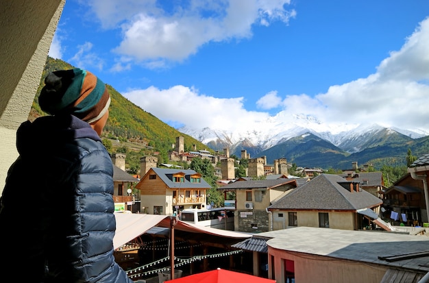 El hombre disfruta de impresionantes vistas de la ciudad de Mestia con casas torre Svan y montañas del Cáucaso, Georgia