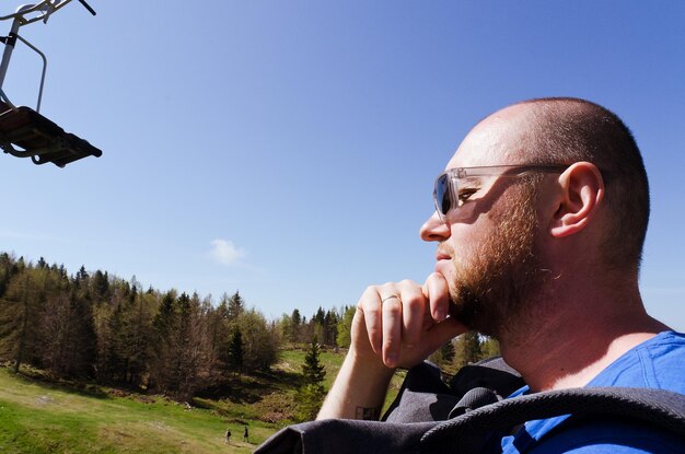 El hombre disfruta de las vistas del pueblo alpino en las montañas. Gran meseta de pastos en los Alpes, Eslovenia. viaje