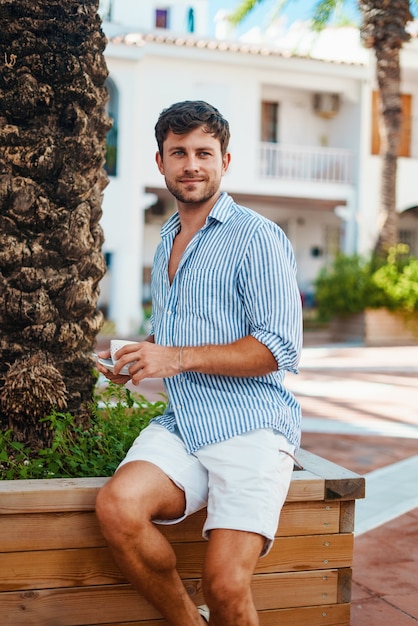 Hombre disfrutando de una bebida caliente en la calle