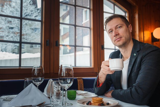 Hombre disfrutando del desayuno en un hotel de lujo en Zermatt, Suiza