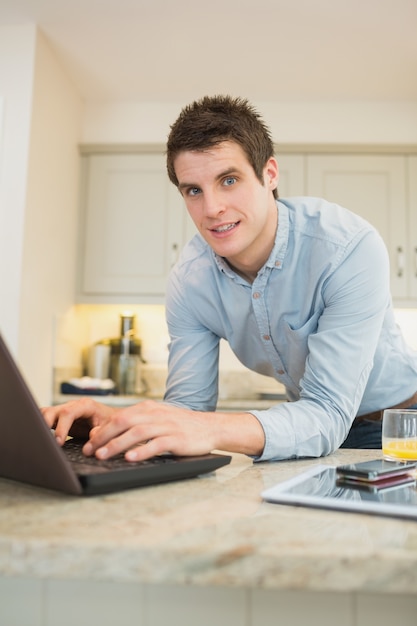 Hombre disfrutando escribiendo en la computadora portátil