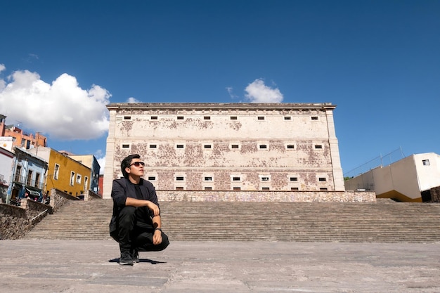 Un hombre disfrutando de la experiencia de viaje cerca de Alhondiga de Granaditas en Guanajuato México bajo un cielo nublado