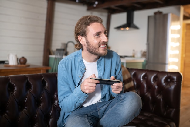 Un hombre disfrutando jugando un nuevo videojuego en casa