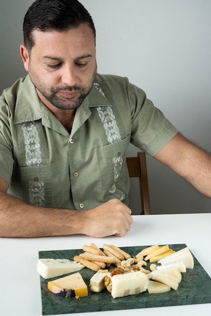 Hombre disfrutando de una tabla de quesos franceses