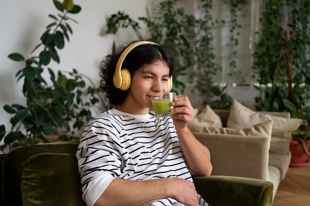 Foto hombre disfrutando de una taza de té matcha en casa