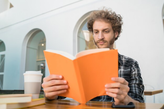 Hombre disfrutando del tiempo libre y leyendo un libro.