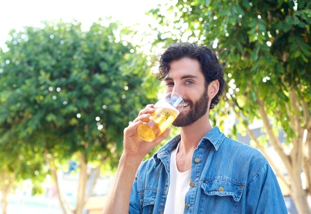 Hombre disfrutando de un trago de cerveza en verano en el bar al aire libre