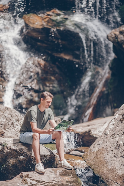 Hombre disfrutando de la vista de la cascada en la selva