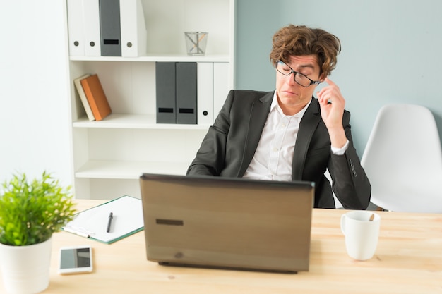 Hombre divertido cansado después de trabajar en la computadora en la oficina