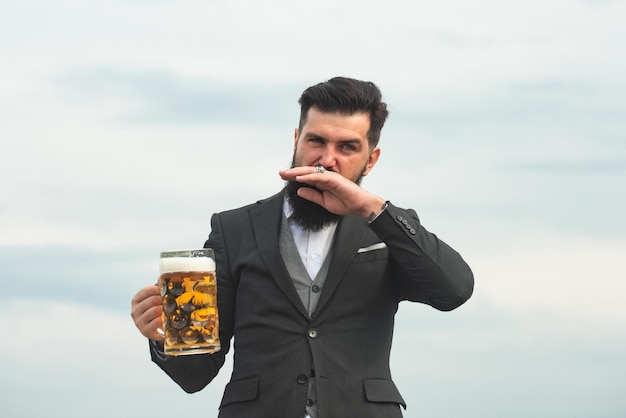 Hombre divertido hipster barbudo tiene cerveza artesanal.