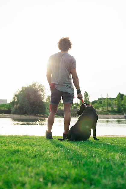 Hombre divirtiéndose y jugando con su perro en el parque.