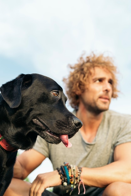 Hombre divirtiéndose y jugando con su perro en el parque.