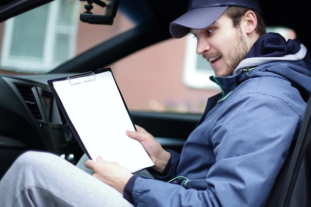 hombre con documentos sentado en el coche