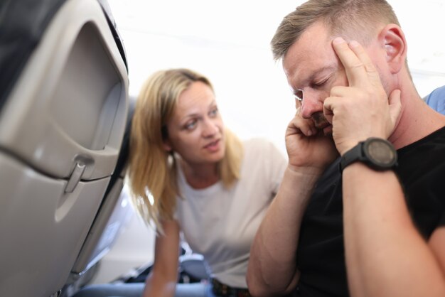 Foto hombre con dolor de cabeza con los ojos cerrados en avión