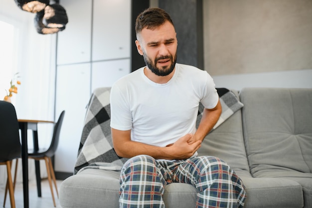 Hombre con dolor de estómago en casa Envenenamiento alimentario