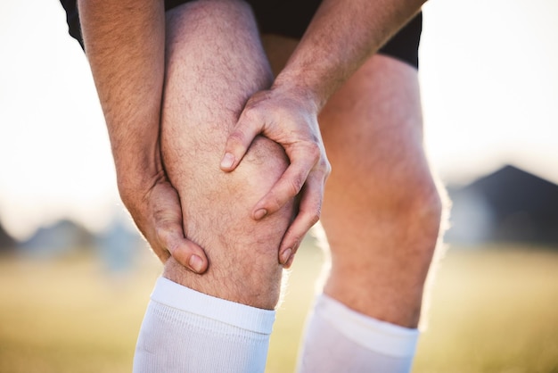 Hombre con dolor de rodilla con lesión y atleta de accidente de fitness al aire libre con calambres y tensión muscular Ejercicio deportivo y hombre con las manos en la pierna crisis de salud y jugador de rugby con inflamación