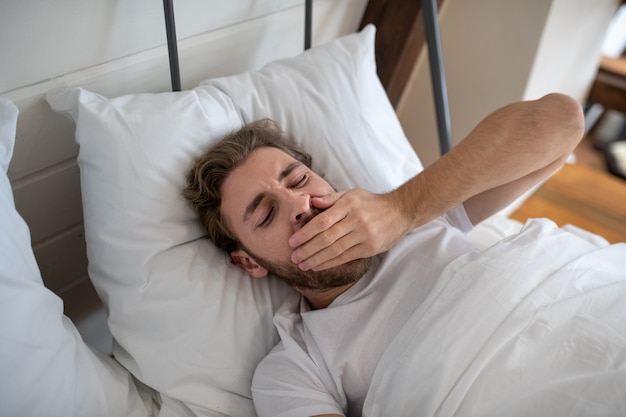 Foto un hombre dormido descansando en su dormitorio por la mañana