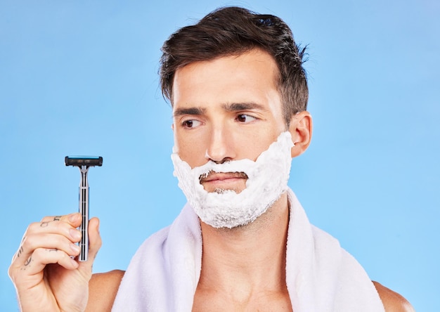 Hombre duda afeitado y cara en estudio con navaja pensando o cosméticos para autocuidado belleza y espuma Aseo facial y cuidado de la piel con crema de afeitar barba y contemplación en el baño