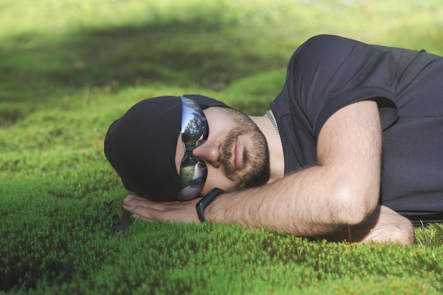 Un hombre duerme sobre musgo verde suave en el bosque