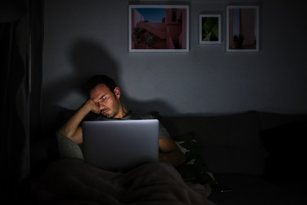 Hombre durmiendo con la computadora en