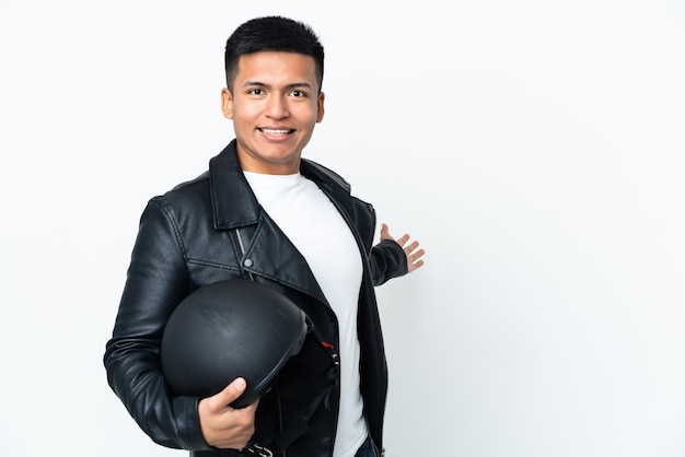 Hombre ecuatoriano con un casco de motocicleta aislado sobre fondo blanco extendiendo las manos hacia el lado para invitar a venir