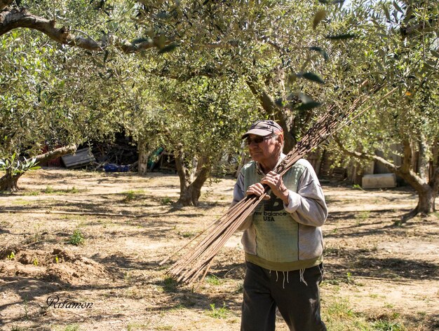 Foto hombre de edad avanzada llevando una barra metálica en el hombro al aire libre