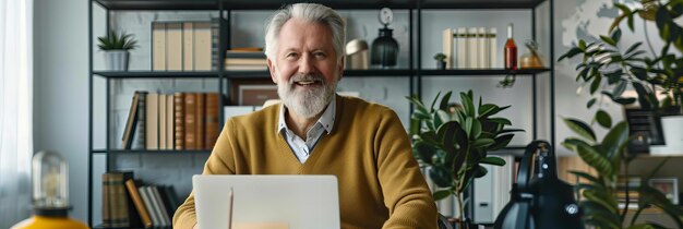 Hombre de edad avanzada sonriente usando una computadora portátil en la oficina del hogar