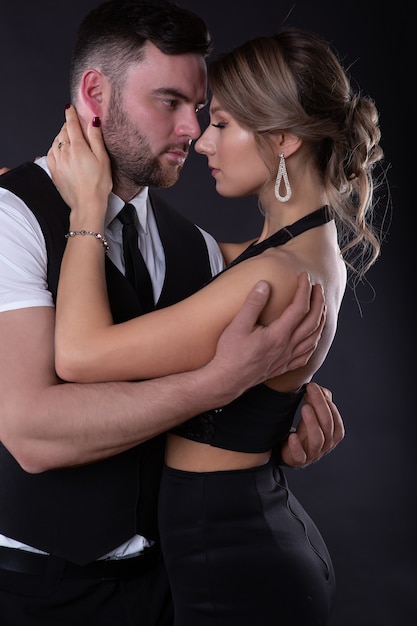 Hombre elegante abraza a su mujer sexy que cerró los ojos con placer