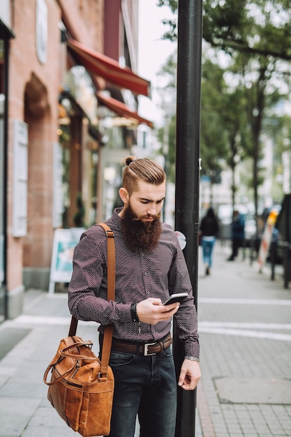 Hombre elegante con barba larga con teléfono