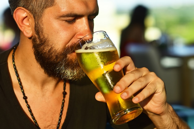 Hombre elegante feliz bebiendo cerveza