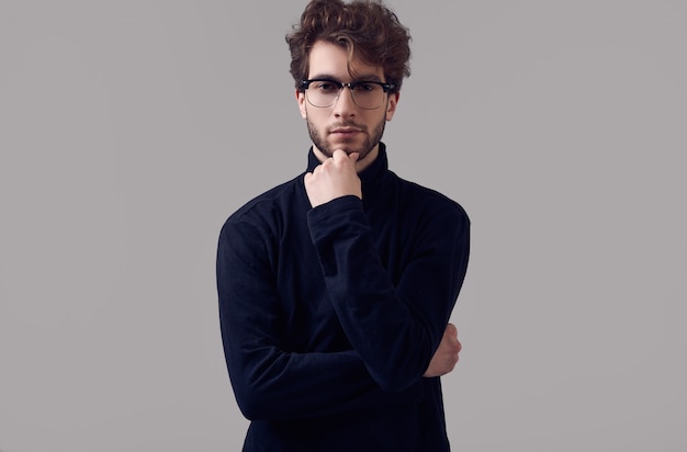 Hombre elegante guapo con el pelo rizado con gafas y cuello de tortuga negro