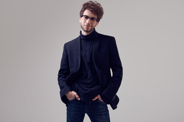 Hombre elegante guapo con el pelo rizado con traje y gafas