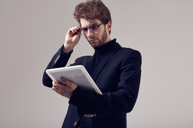 Hombre elegante guapo con el pelo rizado con traje y gafas