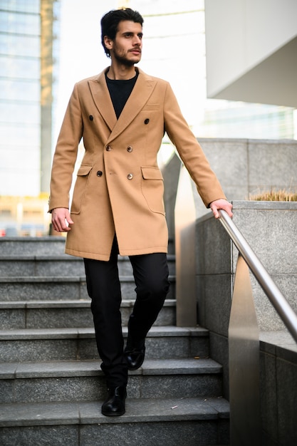 Hombre elegante guapo tomando escaleras en una ciudad moderna