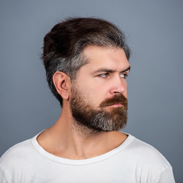 Hombre elegante hermoso sexy. Retrato de un joven apuesto de cerca. Retrato de hombre guapo contra la pared gris.