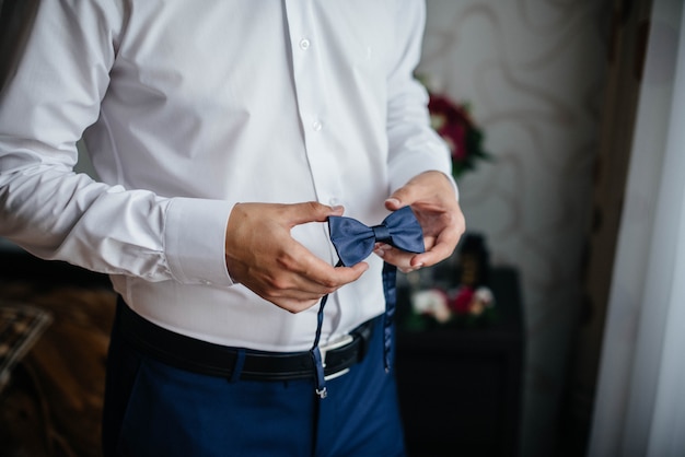 Hombre elegante que sostiene un primer plano de la mariposa. Moda.