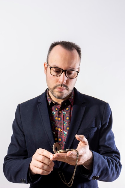 Hombre elegante con un reloj de bolsillo dorado.