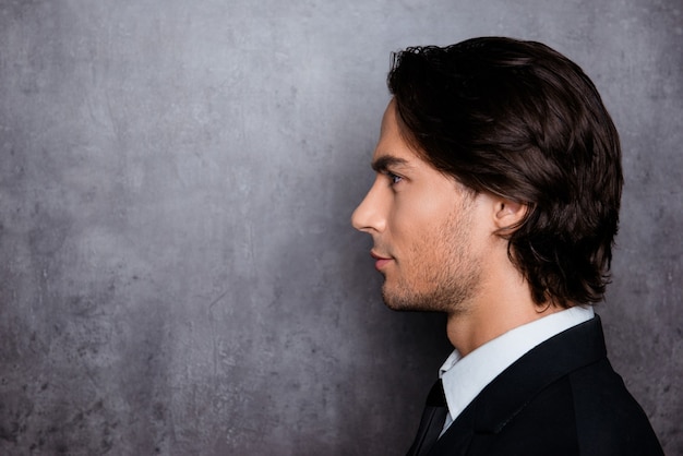 Hombre elegante en ropa formal con barba y cabello hermoso, foto de vista lateral