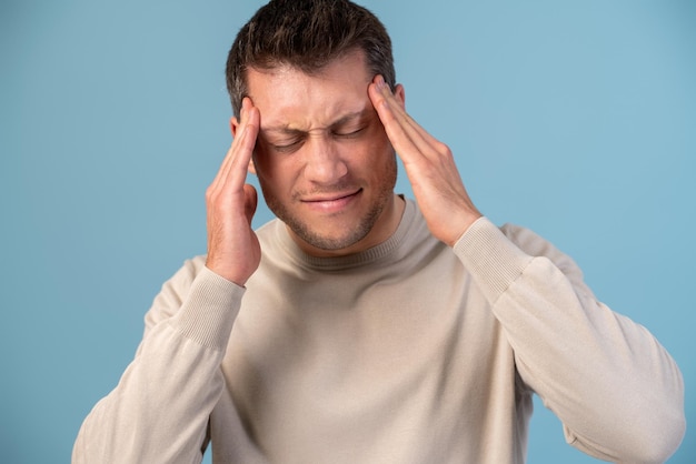 Hombre elegante sobre un fondo aislado con ambas manos en la cabeza por dolor de cabeza debido al estrés. Concepto de migraña que sufre