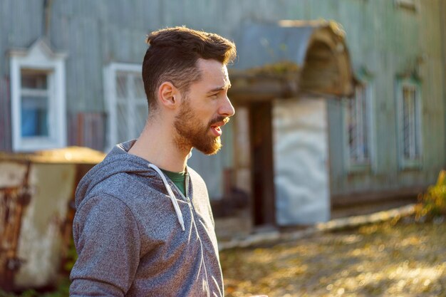 Hombre elegante con una sudadera gris retrato de un joven milenario con barba