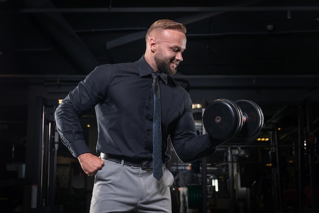 Hombre elegante en un traje de negocios trabaja en el gimnasio. Concepto de negocio y culturismo. Actividades deportivas. Técnica mixta