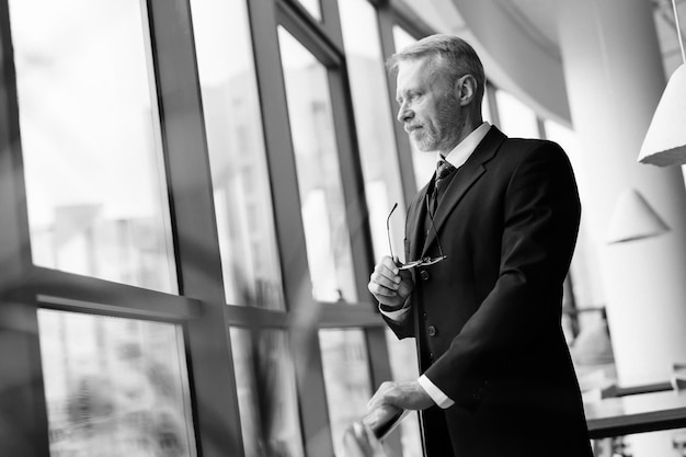 Hombre elegante con traje negro clásico y camisa blanca Una foto en blanco y negro de un hombre con traje