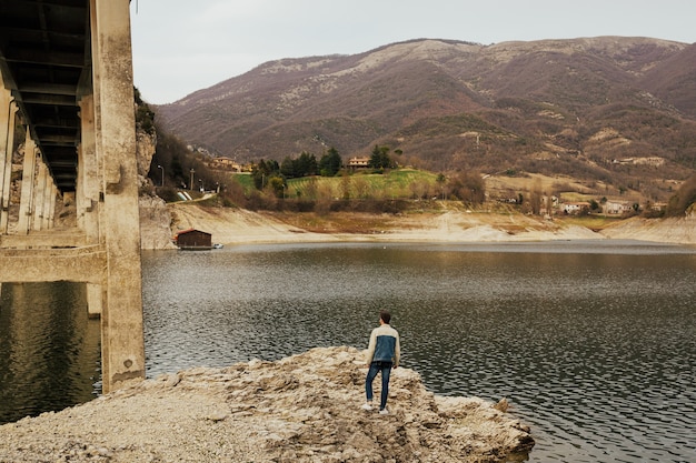 Hombre elegante viendo un paisaje maravilloso en las montañas durante la primavera en Italia.