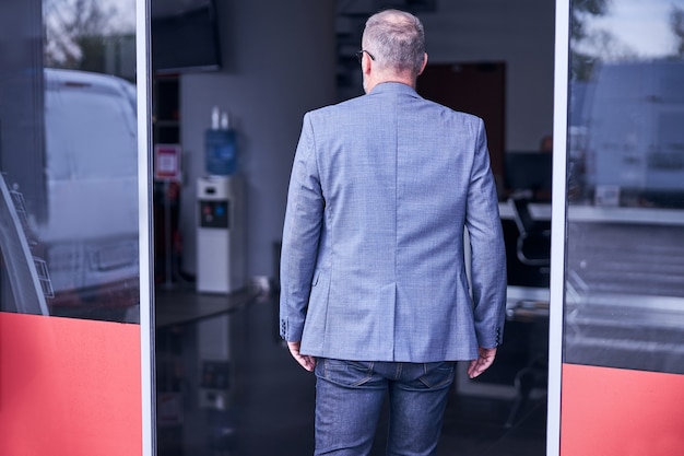 Foto hombre elegante visitando la estación de servicio de reparación de automóviles