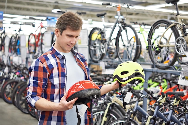 El hombre elige casco para andar en bicicleta