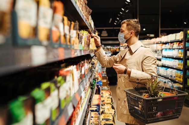 El hombre elige productos de la nevera en el supermercado