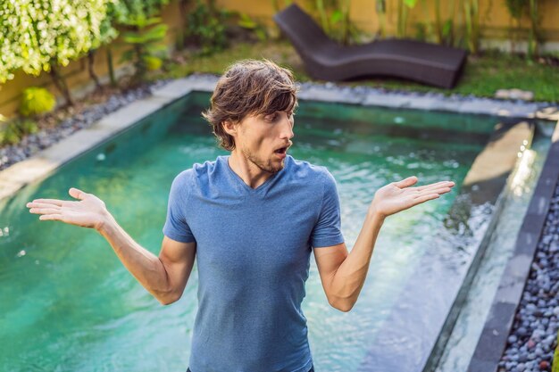 El hombre elige productos químicos para la piscina Servicio y equipo de piscina con productos y herramientas de limpieza química