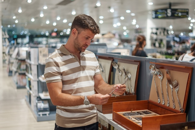 Hombre eligiendo cubiertos en la tienda